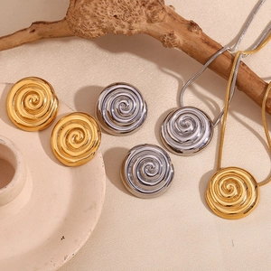 Artistic layout of vintage spiral jewelry sets in gold and silver finish with dried branches