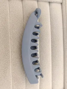 Close-up of a matte blue-gray banana hair clip featuring a multi-tooth interlocking design
