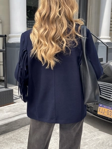 Rear view of navy blue jacket featuring elegant long fringe details on the sleeves