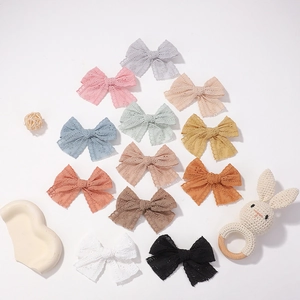 Set of 12 hollow lace bow hair clips for baby girls in various pastel and earth tones