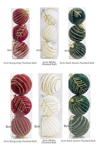 Detail of flocked Christmas balls in wine red, white, and green with gold glitter