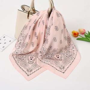 Hellrosa Seidenschal mit Paisley-Muster an einer weißen Handtasche mit Tulpen-Deko
