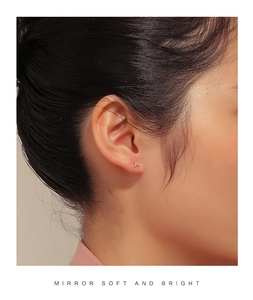Close-up of a model wearing a gold star stud earring with pave zircon stones