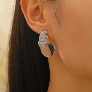 Detailed close-up of water drop earrings with white zircons and translucent grey resin charm