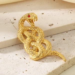 Macro shot of 18k gold snake pendant featuring red eyes and detailed scale texture