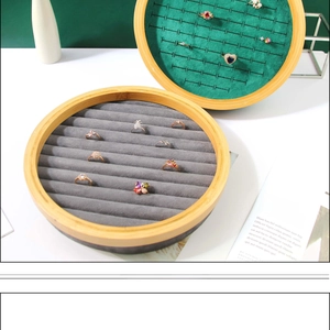 Detail of round solid wood ring display stand with gray velvet slots and natural wood grain