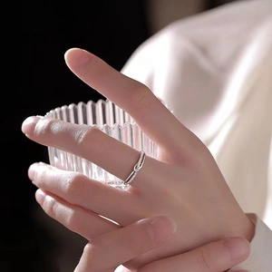 Detail of silver twisted knot ring with micro-pave clear gemstones on a model finger