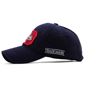 Detail of New York embroidery and white TRADEMARK stitching on navy cotton baseball cap