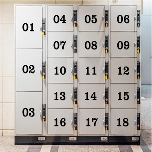 Détail d'un casier métallique gris à 18 compartiments avec étiquettes numérotées