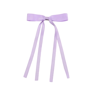 Detail of light purple satin ribbon hair clip with long streamers on a white background