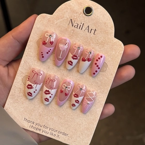 Detail of pink and white almond press-on nails with 3D bows and rhinestone accents