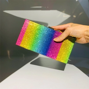 Macro shot of shimmering rainbow rhinestones on a rectangular luxury evening clutch bag