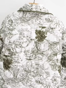Détail de veste matelassée blanche avec liseré vert et imprimé nature vintage