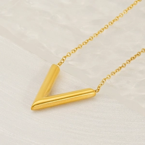 Minimalistische 18k vergulde titanium V-hanger ketting op een zachte witte stoffen achtergrond