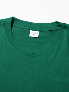 Close-up of neckline detail on green 100% cotton T-shirt with M size label