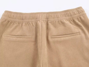 Détail du pantalon large kaki avec taille élastique, poches et texture de tissu sergé
