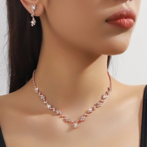 Dettaglio del set collana e orecchini a fiore in oro rosa con pietre scintillanti