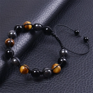 Detailed view of 10mm tiger eye and onyx beads on a hand-woven adjustable cord bracelet