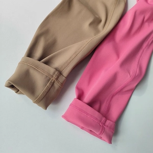 Detail of high-elasticity yoga leggings with professional flatlock stitching in brown and pink