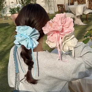 Lace ruffle scrunchies with ribbon bows shown on models in a soft outdoor lawn setting