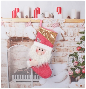 Détail d'une chaussette de Noël rouge avec peluche Père Noël 3D et sequins dorés brillants