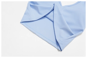 Détail de la couture à double aiguille sur l'ourlet d'un soutien-gorge de yoga bleu clair