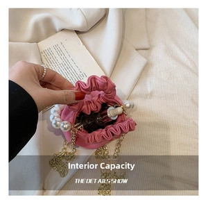 Detail showing internal capacity of the pink pleated bucket bag with pearl handle