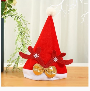 Close-up of red velvet Christmas hat with glitter antlers and golden bow decoration