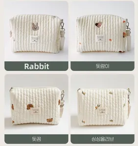 Close-up of quilted cotton pouches featuring bear, rabbit, squirrel, and olive embroidery