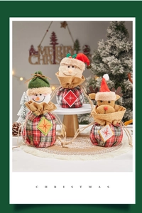 Detailed close-up of Christmas drawstring gift bags featuring Santa, snowman and reindeer