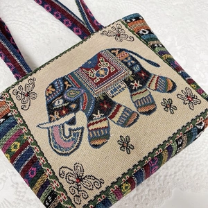 Detailed close-up of ethnic embroidered canvas tote with colorful elephant jacquard texture