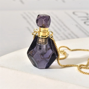 Macro shot of purple crystal flame perfume bottle necklace with gold metal cap