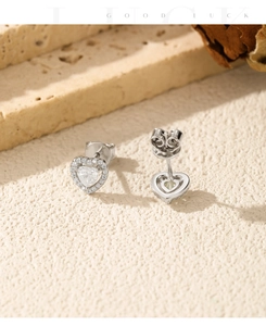Macro view of heart-shaped moissanite earrings on a textured stone surface