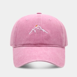 Close-up of mountain peak embroidery and washed cotton texture on pink baseball cap
