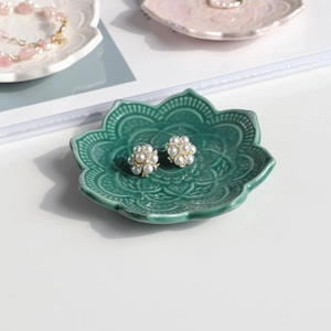 Nordic gold flower earrings with pearls on a green mandala ceramic jewelry tray