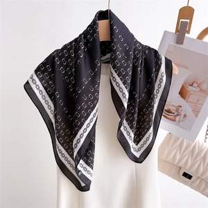 Classic black and white checkered silk scarf with chain print on a wooden hanger