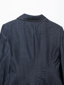 Dettaglio della cucitura posteriore e della spalla di una giacca blazer in denim blu scuro