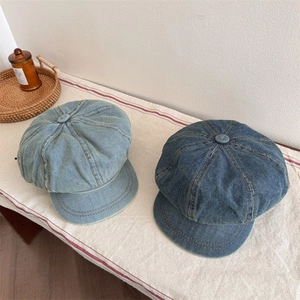 Berretti newsboy in denim vintage azzurro e blu scuro su superficie in tessuto