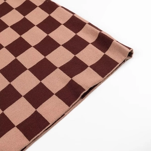 Gros plan sur la texture du tricot à damier marron et beige avec motif tissé doux