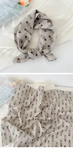 Detailed view of beige cotton linen scarf featuring brown fish print and soft texture
