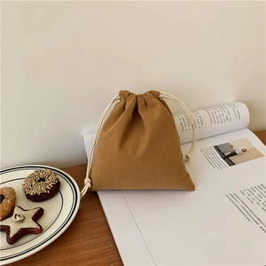 Detailed texture of brown cotton linen drawstring gift bag with cream white ropes