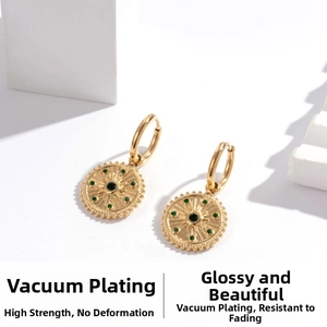 Close-up of gold drop earring with green zircon pendant featuring vacuum plating finish