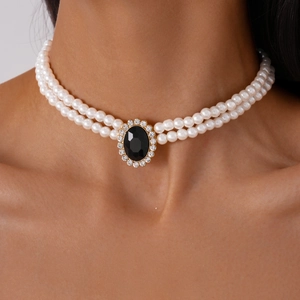 Detail of double-layer faux pearl choker with an oval black gemstone and gold setting