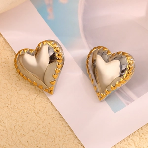 Detail of heart earrings featuring silver finish and 18K gold-plated scalloped edges