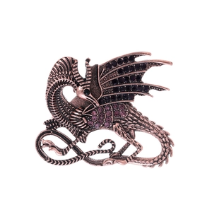 Detailed view of an antique bronze dragon brooch with purple rhinestones and scales