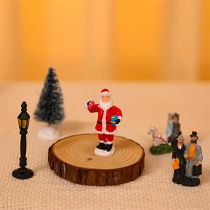 Detailed Christmas village scene featuring Santa Claus and vintage street lamps on wood base