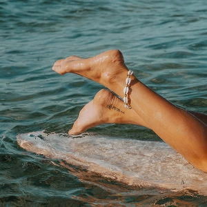 Bracelet de cheville réglable bohème avec coquillages blancs et perles dorées sur la plage