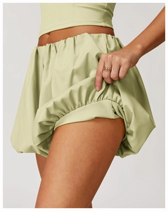 Close-up of light green quick-dry yoga shorts with elastic waist and pleated bubble hem
