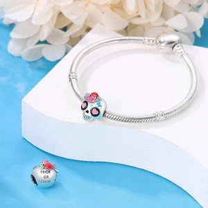 Detailed shot of silver skull bead and Trick or Treat charm on a snake chain bracelet