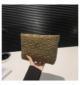 Detail of olive brown quilted floral pouch featuring minimalist 3D daisy pattern texture